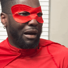 a man wearing a red cape and red mask