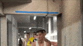 a group of men walking down a hallway with a blue tape on the ceiling