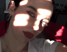 a close up of a woman 's face with the sun shining on her face
