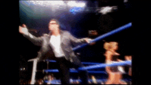 a blurry picture of a man in a wrestling ring with a woman in the background .