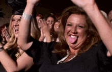 a woman sticking her tongue out at a crowd of people
