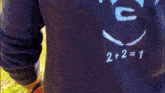 a person wearing a blue sweatshirt with a picture of a man and the numbers 2 + 2 = 1 on it
