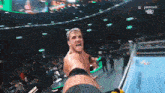 a man is standing in a wrestling ring with a peacock logo in the background .