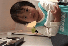 a little girl wearing a blue shirt that says ' o'neill ' on it