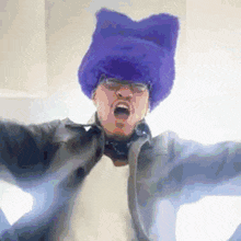 a man wearing a purple furry hat and glasses is dancing .