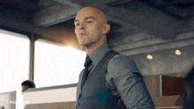 a bald man in a suit and tie with the hashtag #superman on the bottom right