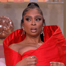 a woman wearing a red dress has a ponytail and a ring on her finger