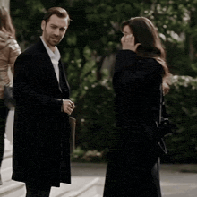 a man and a woman are standing next to each other talking