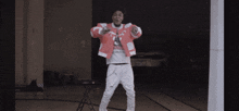 a man in a red jacket with the letter t on it is dancing