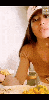 a woman wearing a white nike hat is eating a plate of food