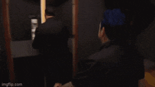 a man in a suit walks down a hallway with imgflip.com on the bottom right