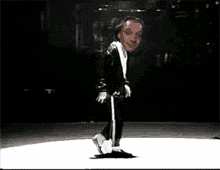 a man in a blue jacket and white pants is dancing on a white surface