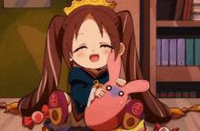 a little girl with a crown on her head is holding a stuffed rabbit