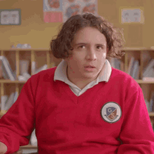 a person wearing a red sweater with a patch that says gs on it