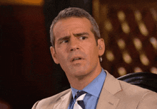 a man in a suit and tie is sitting in a chair