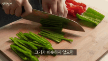 a person is cutting green peppers on a cutting board with a knife