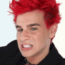 a man with red hair and a nose ring making a funny face