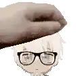 a hand is holding a child 's head with glasses on .