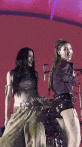 two women are dancing on a stage with a red background and the words sxrinz on the bottom