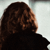 a close up of a woman 's hair and a black jacket