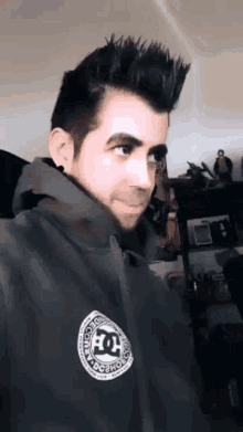 a man with a beard wearing a dc sweatshirt