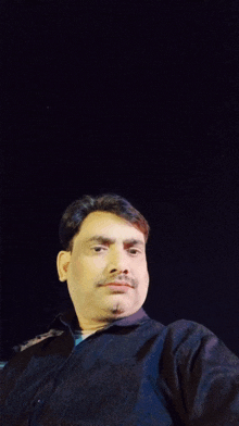 a man with a mustache is standing in a crowded room