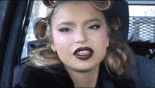 a woman with curlers in her hair is wearing lipstick