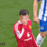 a man wearing a red snapdragon shirt holds his head
