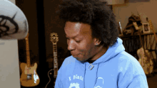 a man wearing a blue hoodie that says i hate on it