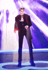 a man in a suit is standing on a stage with a purple background .