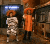a couple of people wearing sombrero 's and poncho 's are dancing in a hallway