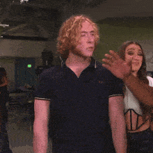 a man with curly hair is being slapped by a woman