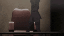 a person with a hood on their head sits in a chair