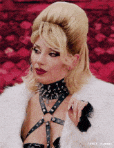 a woman wearing a fur coat and a spiked choker necklace