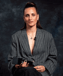 a woman wearing a striped jacket is smiling and holding a box