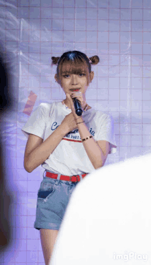 a girl singing into a microphone wearing a california shirt