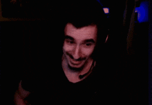 a man with long hair and a mustache is wearing headphones in the dark