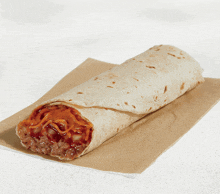 a burrito on a piece of brown paper