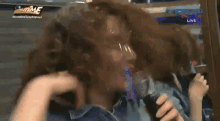 a woman is holding a microphone in front of her face while sitting down .