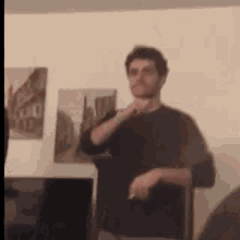 a man in a black shirt is standing in a living room .