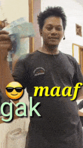a man in a black shirt is holding a stack of money in his hand