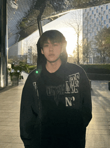 a young man wearing a black hoodie that says n on it