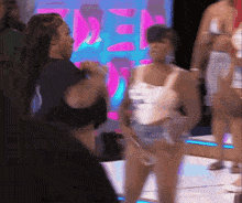 a group of women are dancing in front of a sign that says ' den '