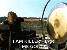 a man playing a gong with the words " i am killer hear me gong " below him
