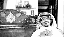 a black and white photo of a man wearing a white shirt and a keffiyeh