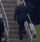 a man in a suit is walking up a set of stairs .