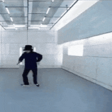 a man is dancing in a room with a blue floor and a white wall .