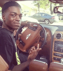 a man is sitting in a bentley car and giving the middle finger