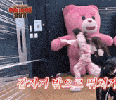 a giant pink teddy bear is being held by two women