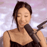 a woman stands in front of a microphone that has the word rode on it